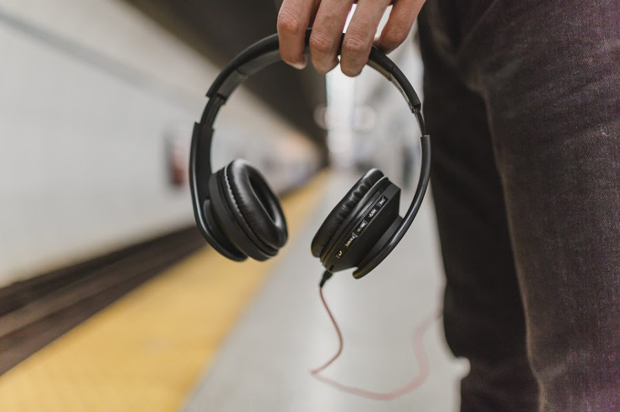 Teen at subway holding headphones 