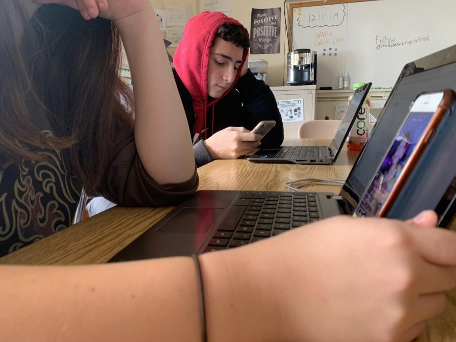 Two NYC iSchool sophomores are using their phones; watching Tik Tok videos and texting their friend on Snapchat during class.