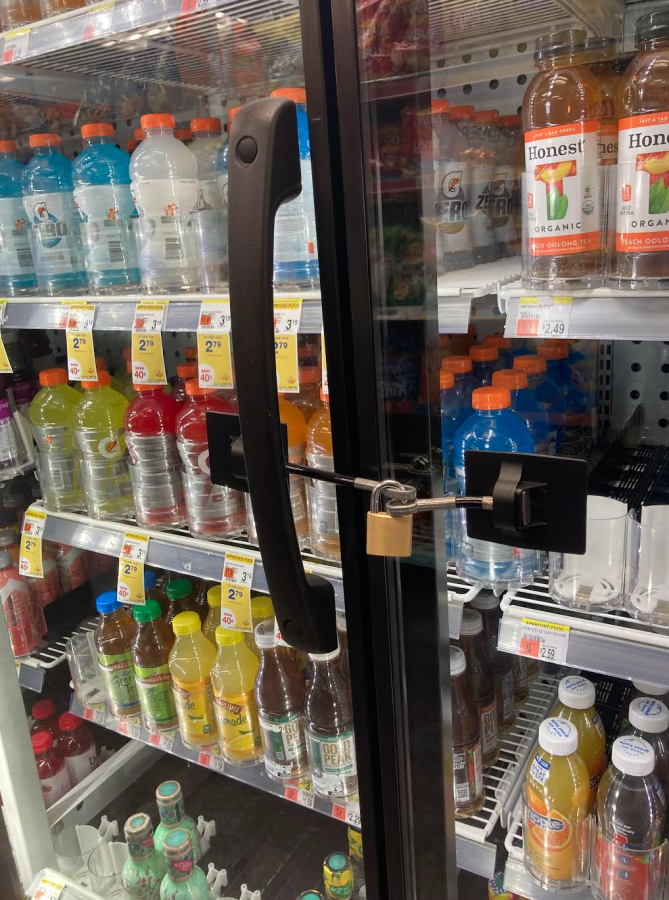 A collection of drinks behind a lock at a CVS. 