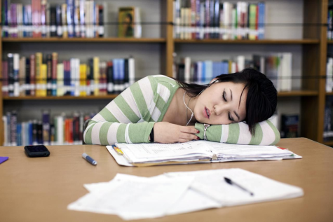 A picture of a girl falling asleep after studying. 