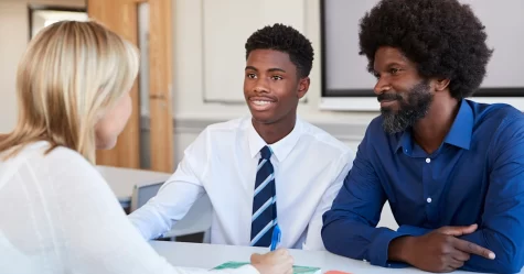 A father and son having a meeting with the son's teacher. 